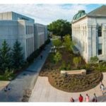 Aerial view of a university campus with modern and classical buildings, landscaped paths, trees, and students walking around.